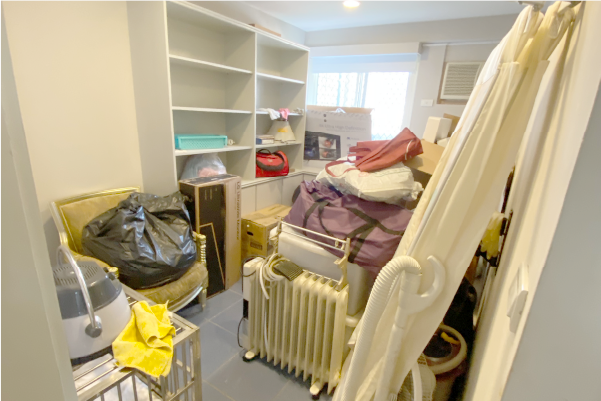 雜亂的儲藏室裡有架子、箱子、袋子和各種物品。明亮的光線從窗戶射入。