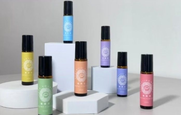 白色表面上擺放著各種顏色和設計的精油滾珠瓶。