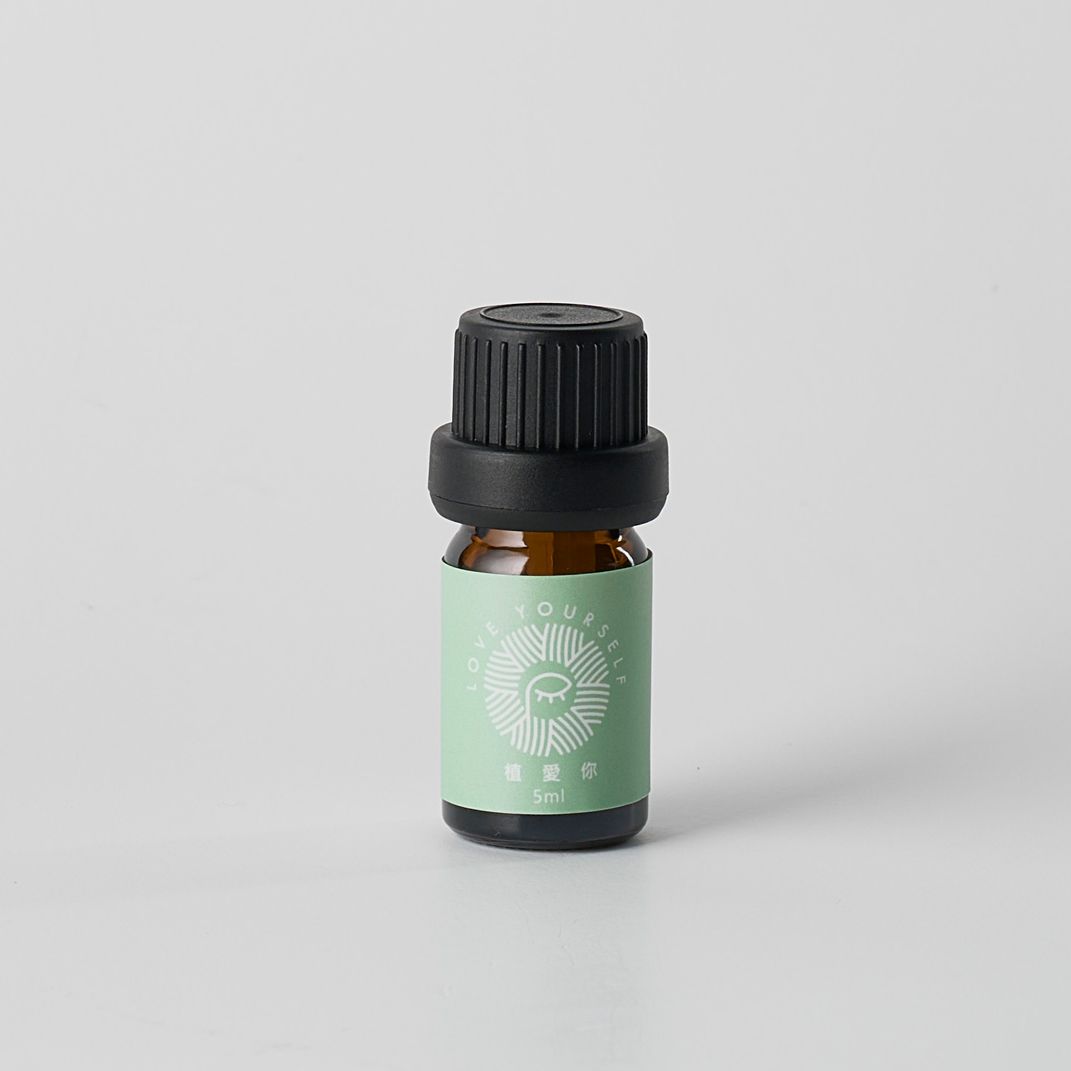 白色背景上的小型棕色精油瓶，黑色瓶蓋，綠色標籤。