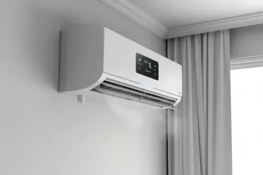 White tankless water heater mounted on a pale green wall with copper pipes.