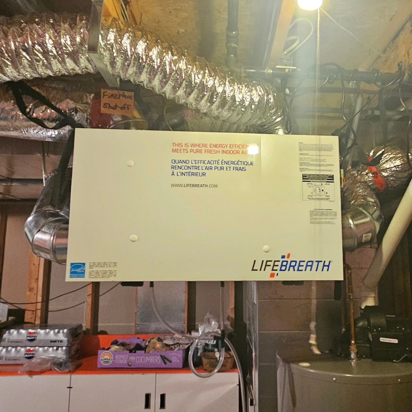 White Lifebreath ventilation system in a basement with ductwork and a water heater.
