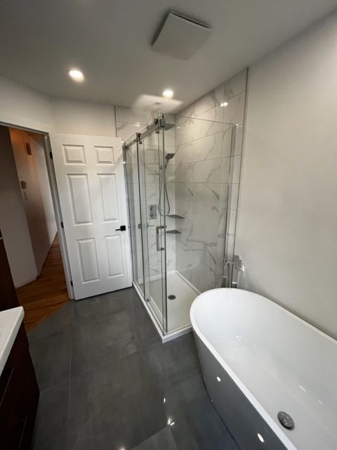 Une salle de bain avec baignoire et douche à l'italienne.