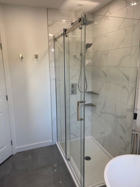 Une salle de bain avec une douche à l'italienne et un lavabo.