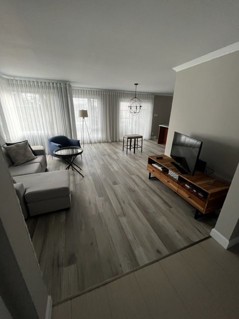 Un salon avec un canapé, une chaise, une table et une télévision.