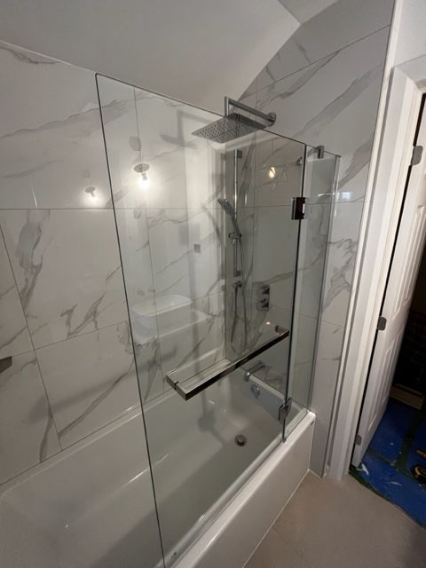 Une salle de bain avec une baignoire et une douche avec une porte vitrée