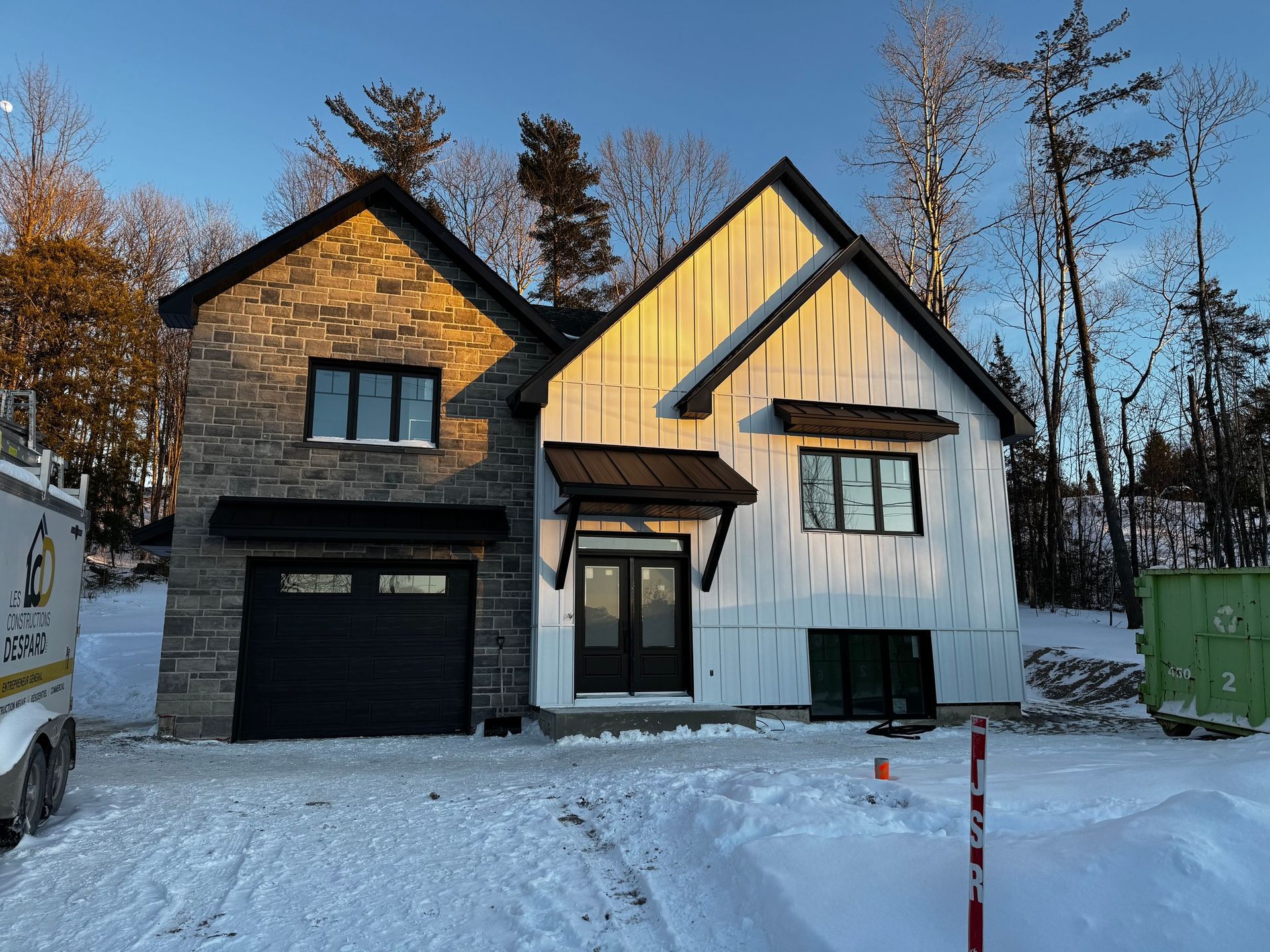Une maison est en construction dans la neige et dispose d'un garage.