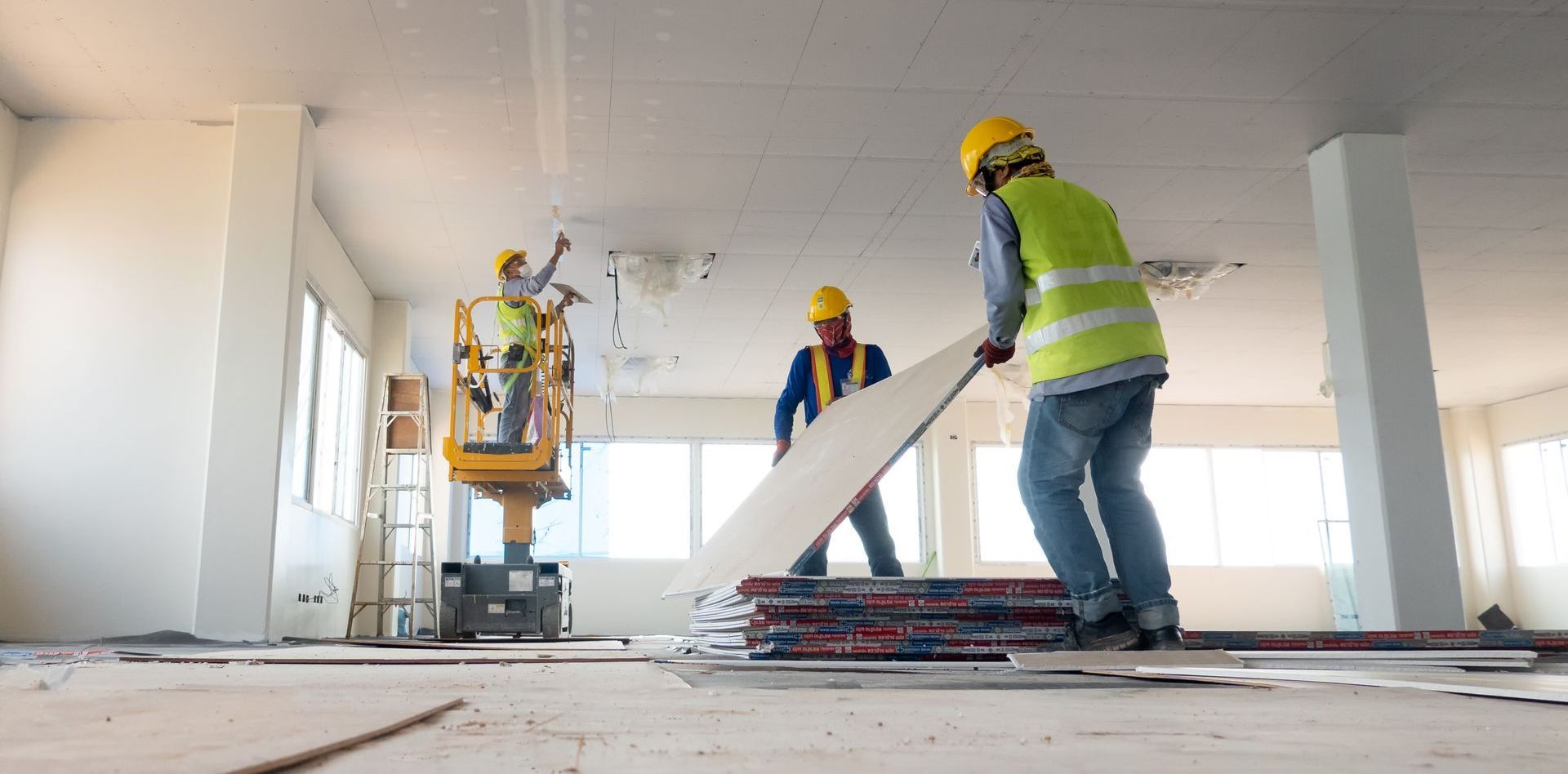 Un groupe d'ouvriers du bâtiment travaille sur un grand bâtiment.