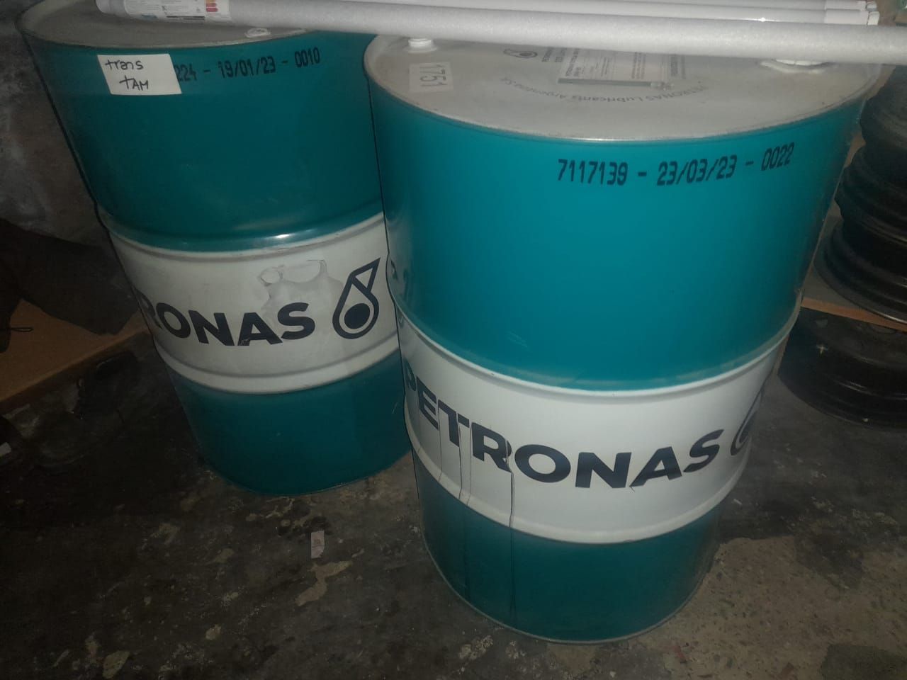Dos bidones de petróleo Petronas de color verde azulado y blanco.