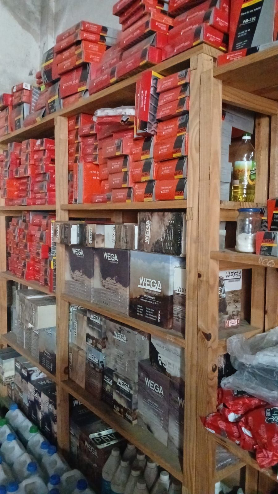 Estantes llenos de artículos en cajas rojas y marrones, posiblemente herramientas o ferretería.
