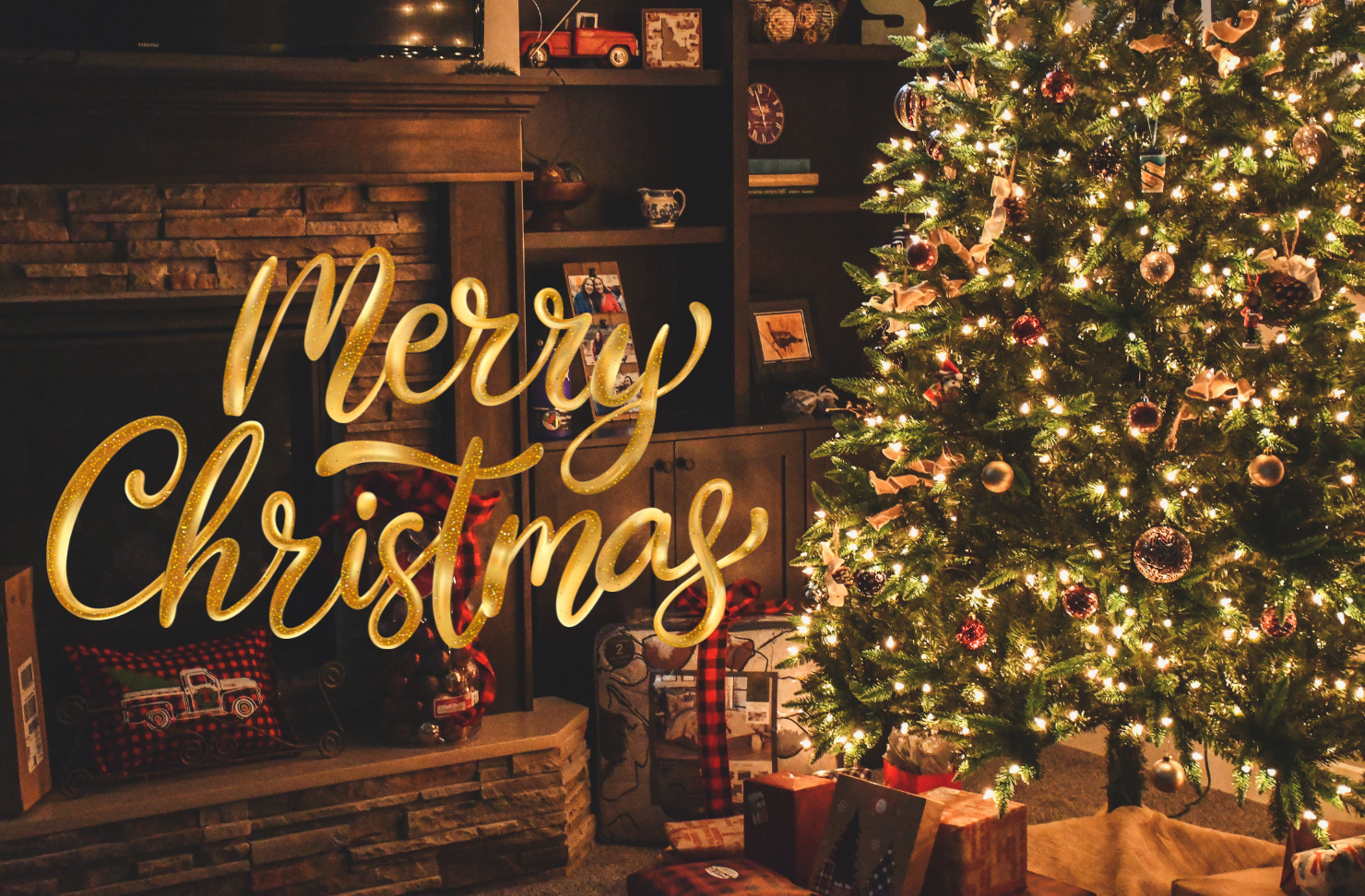 A living room decorated for christmas with a christmas tree and a sign that says merry christmas.