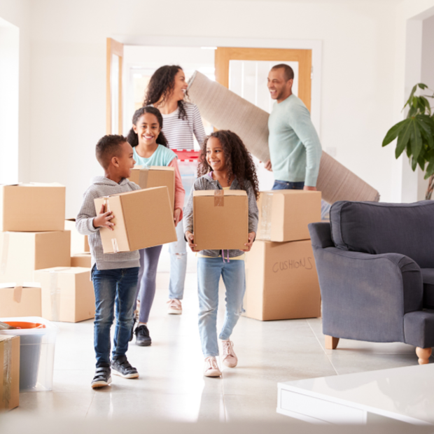 A man and woman holding a sign that says home sweet home