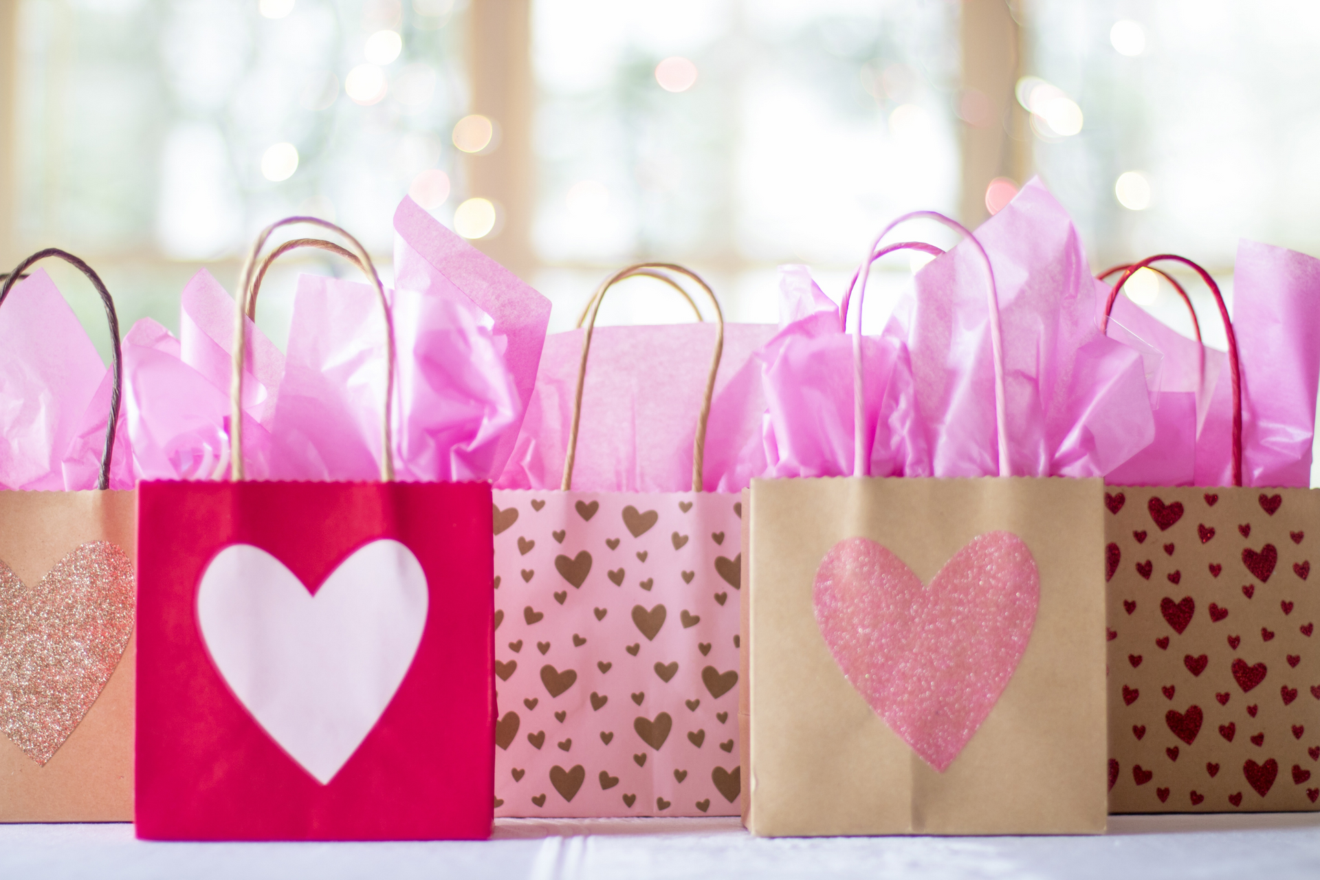 a row of paper bags with hearts on them are lined up on a table .