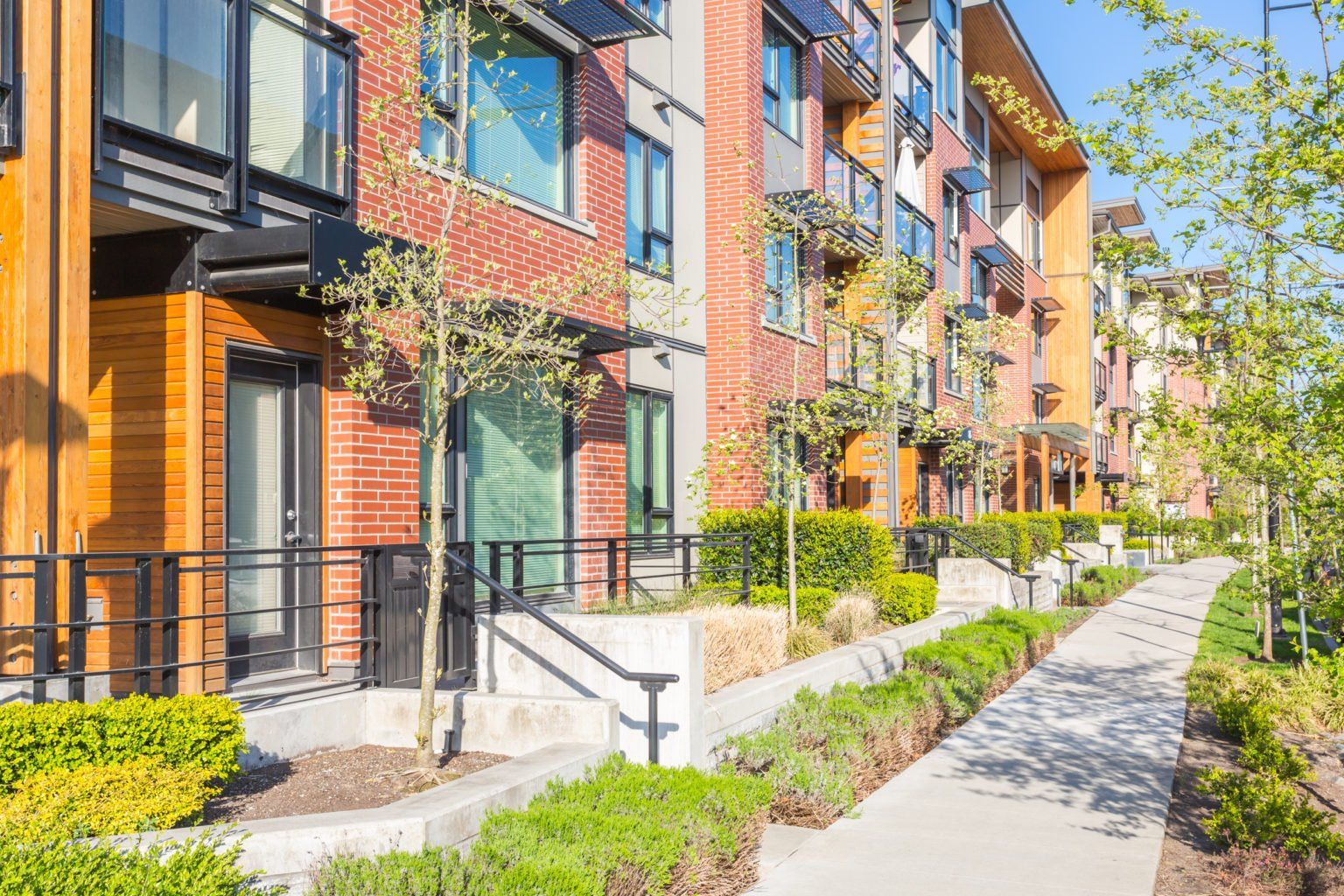 condo complex with brick sides and young trees and shrubs