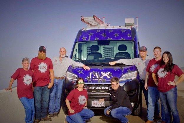 A group of people posing in front of a jax van