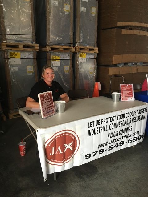 A man sits at a table with a jax sign on it