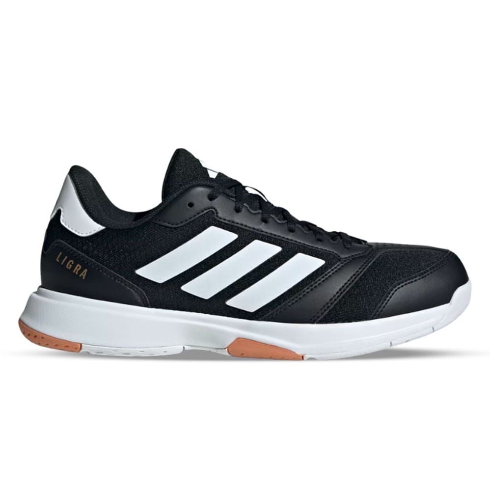 Zapatilla deportiva Adidas Ligra 7 en color blanco y negro con rayas blancas y suela marrón.