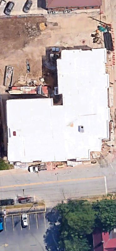 Overhead view of a building with a white roof under construction