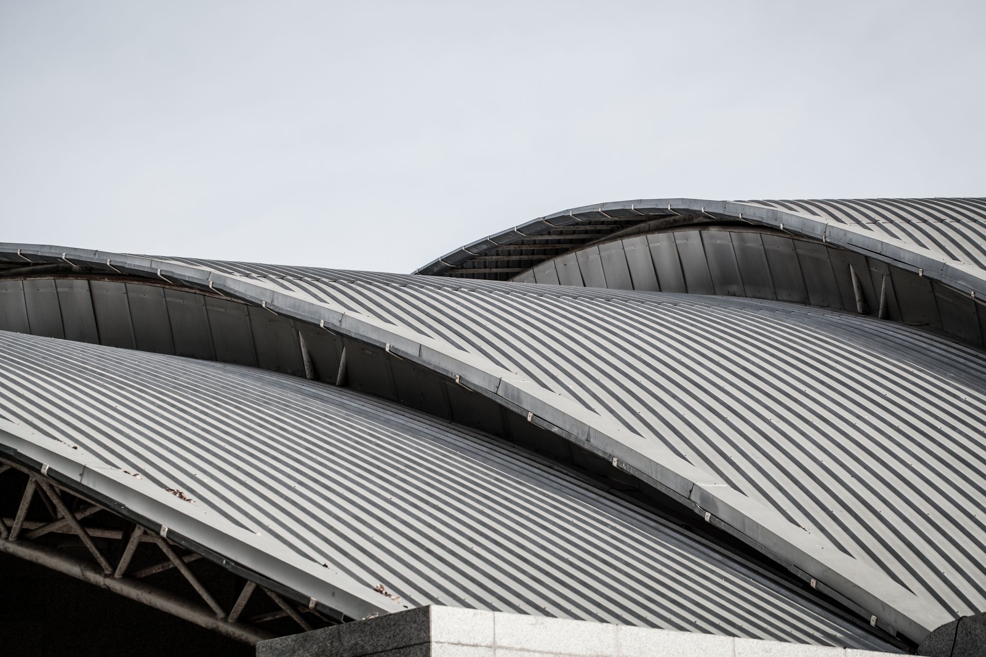Curved, corrugated metal roof of a building against