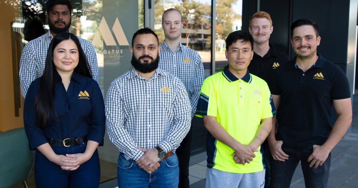 A Group of People Are Posing for a Picture — Moltus Construction in Braddon,  ACT