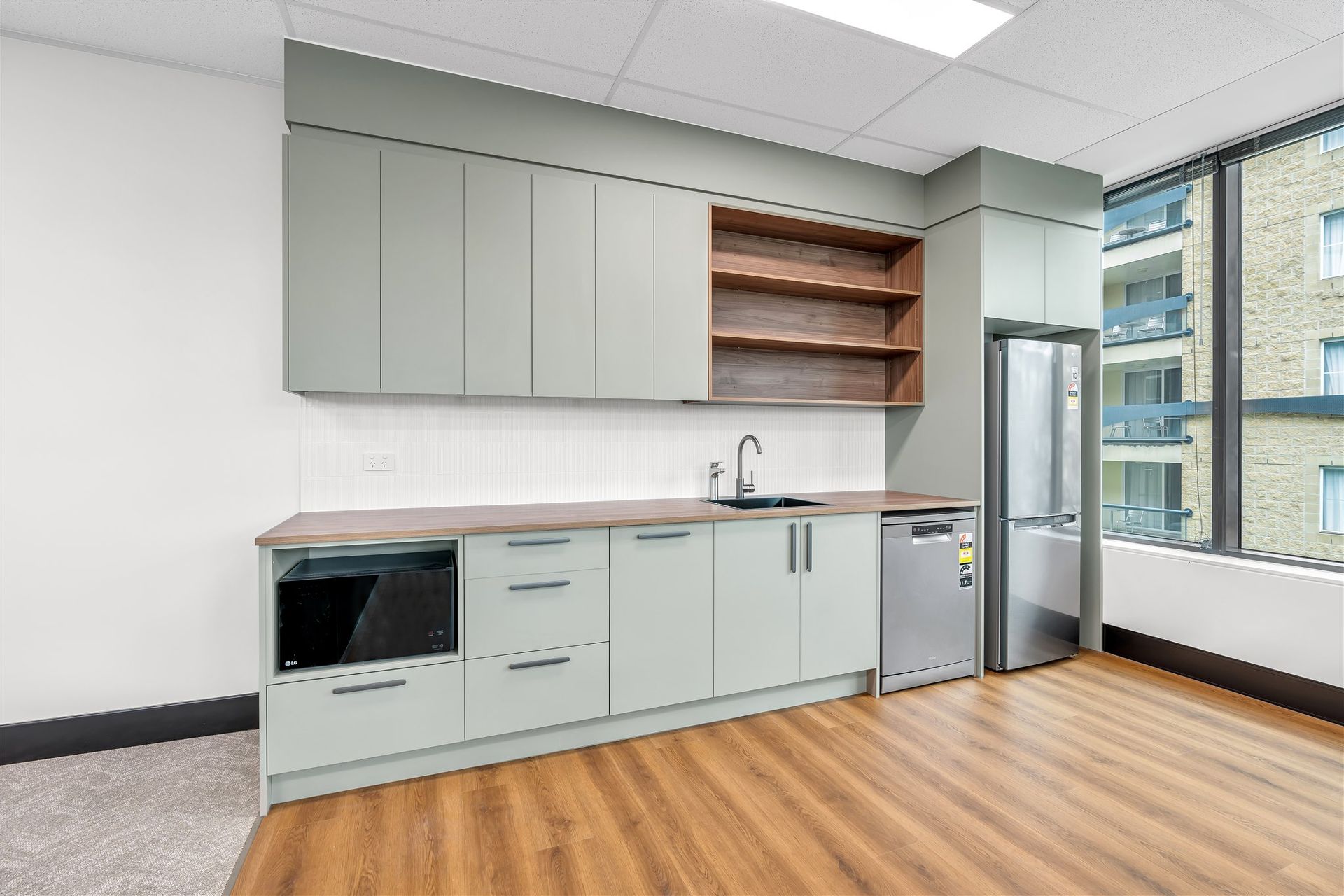 A Kitchen With a Sink, Refrigerator, Dishwasher and Microwave — Moltus Construction in Braddon,  ACT