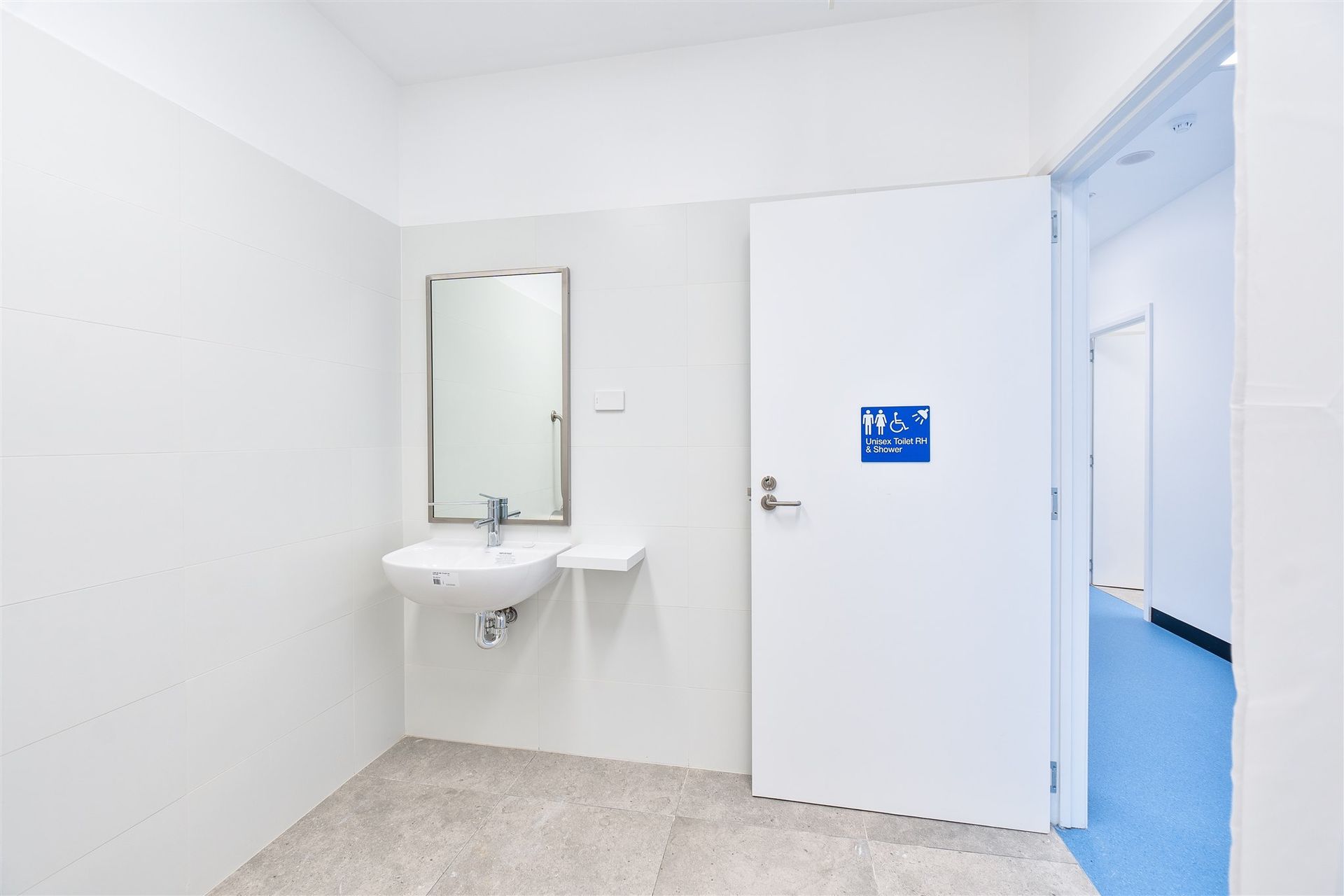 A Bathroom With a Sink, Mirror and Door — Moltus Construction in Braddon,  ACT
