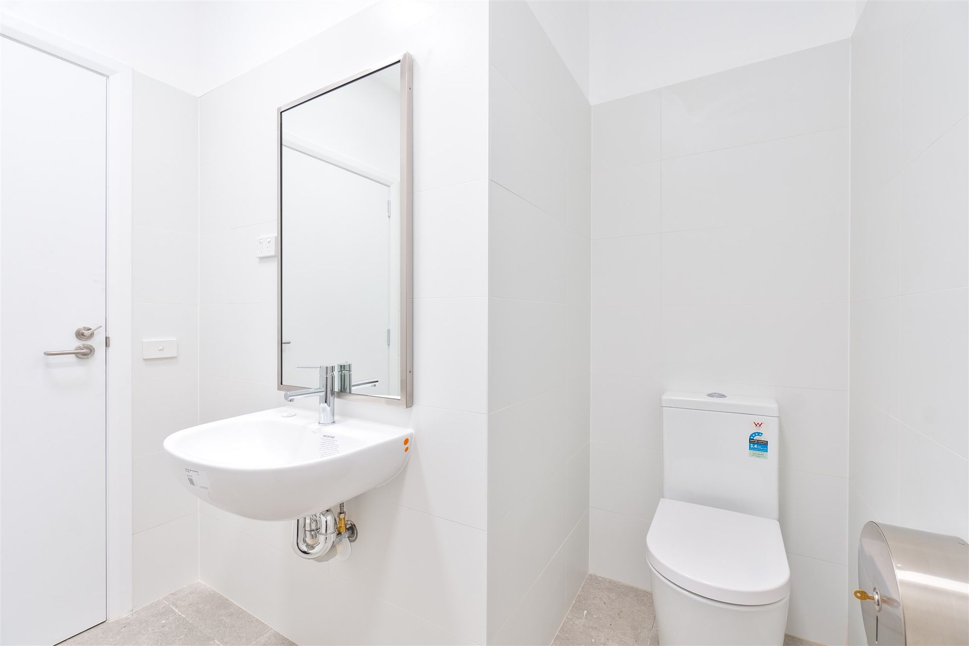 A Bathroom With a Sink, Toilet and Mirror — Moltus Construction in Braddon,  ACT