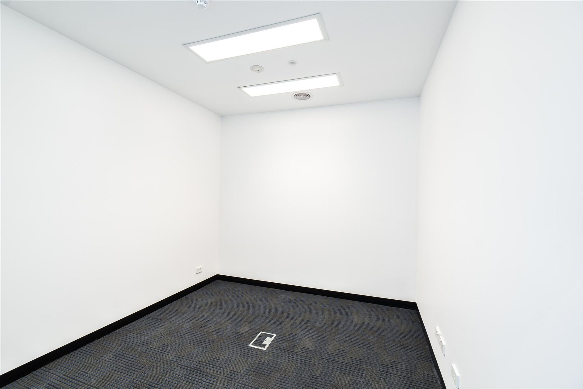 An Empty Room With a Black Carpet and White Walls — Moltus Construction in Braddon,  ACT