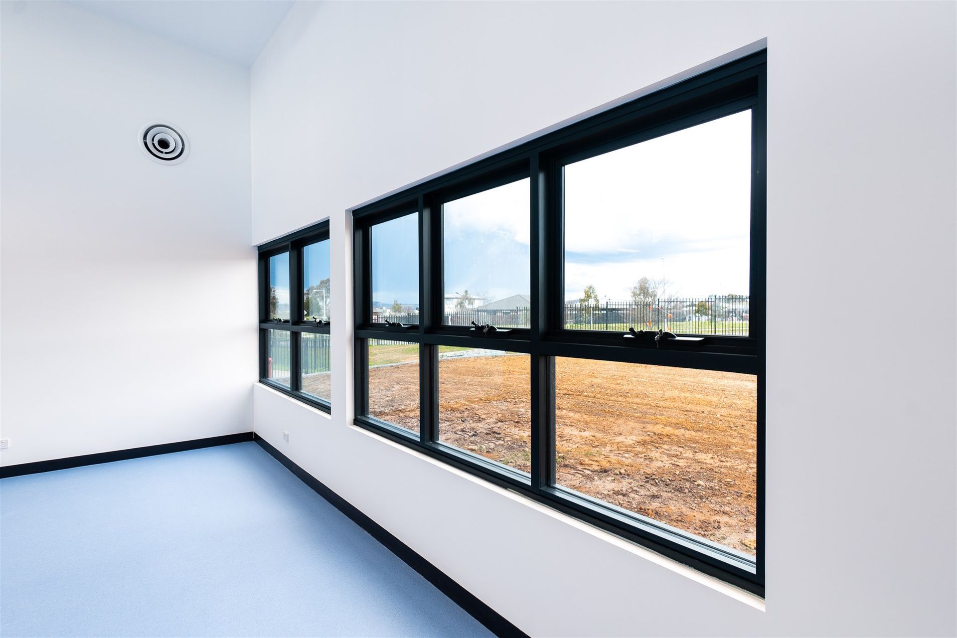 A Room With a Lot of Windows and a Blue Floor — Moltus Construction in Braddon,  ACT