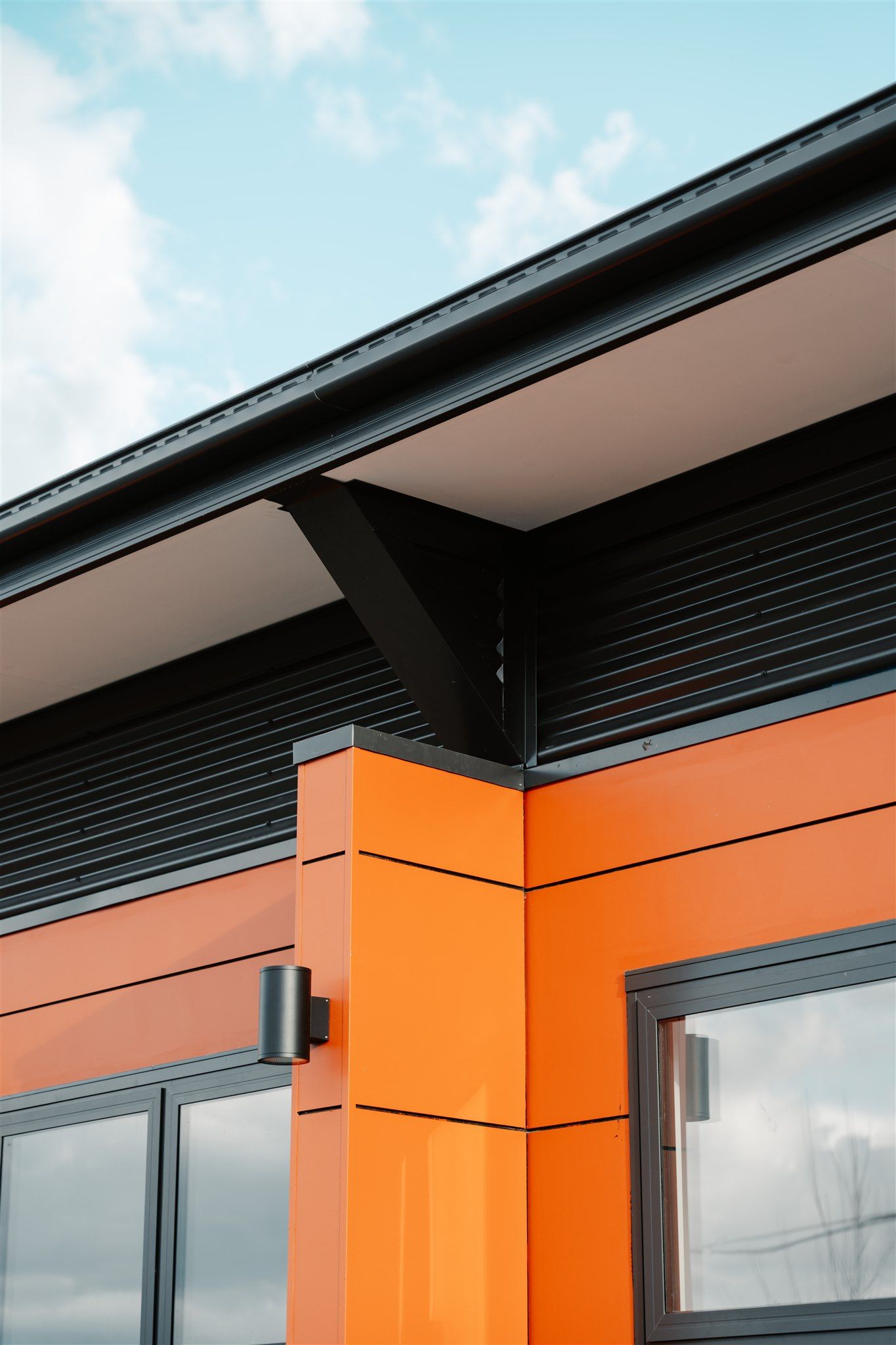 A Close Up of an Orange Building With a Black Roof — Moltus Construction in Braddon,  ACT