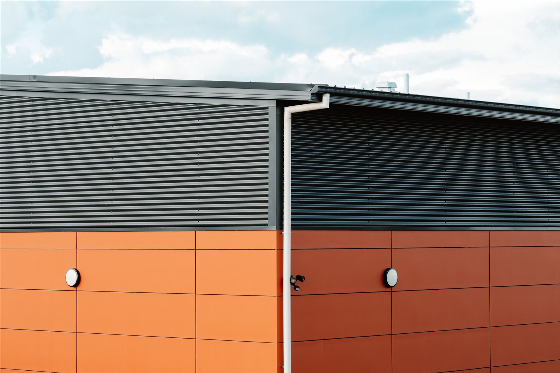 A Building With a Black Roof and Orange Walls — Moltus Construction in Braddon,  ACT