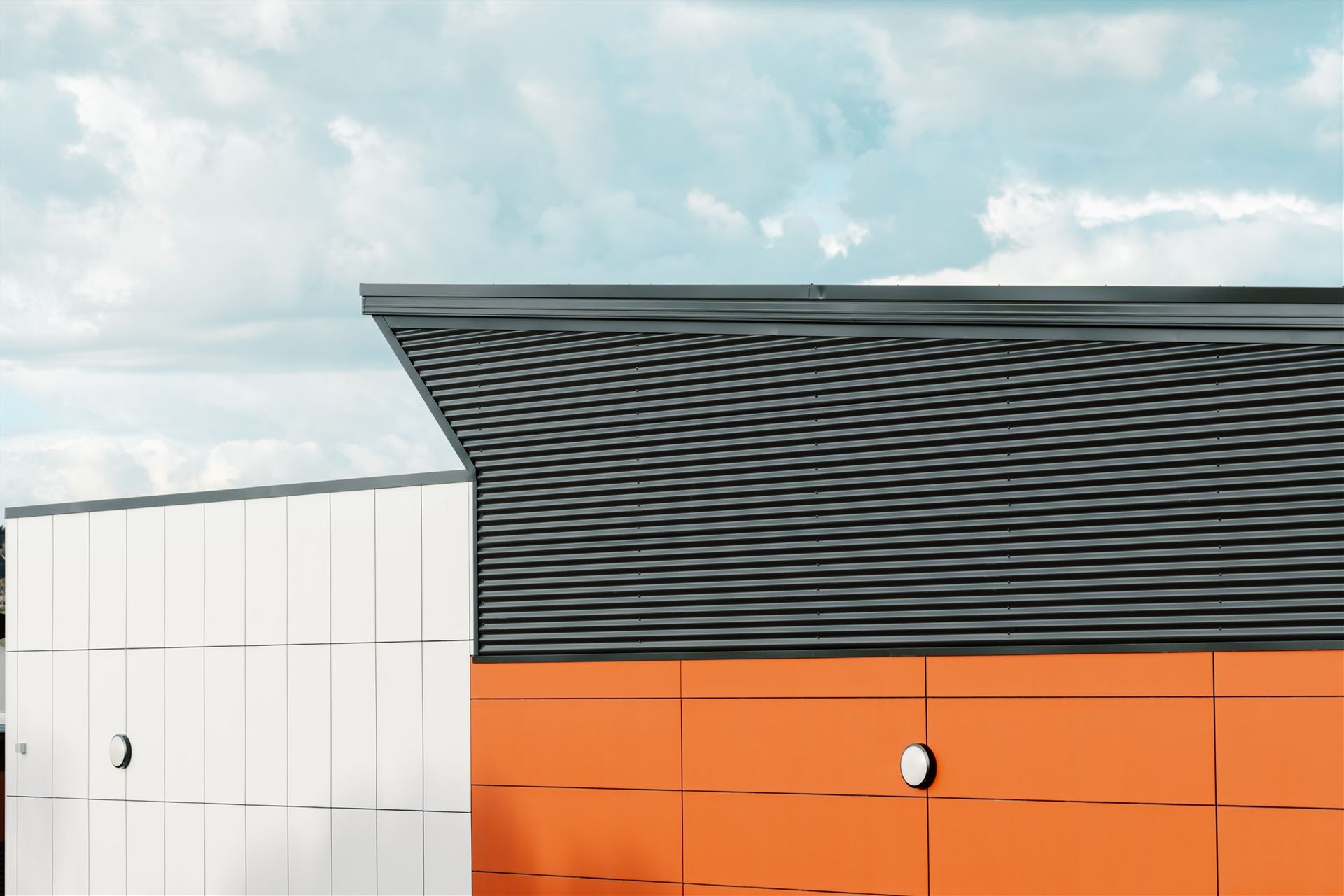 A Building With Orange and White Walls and a Black Roof — Moltus Construction in Braddon,  ACT