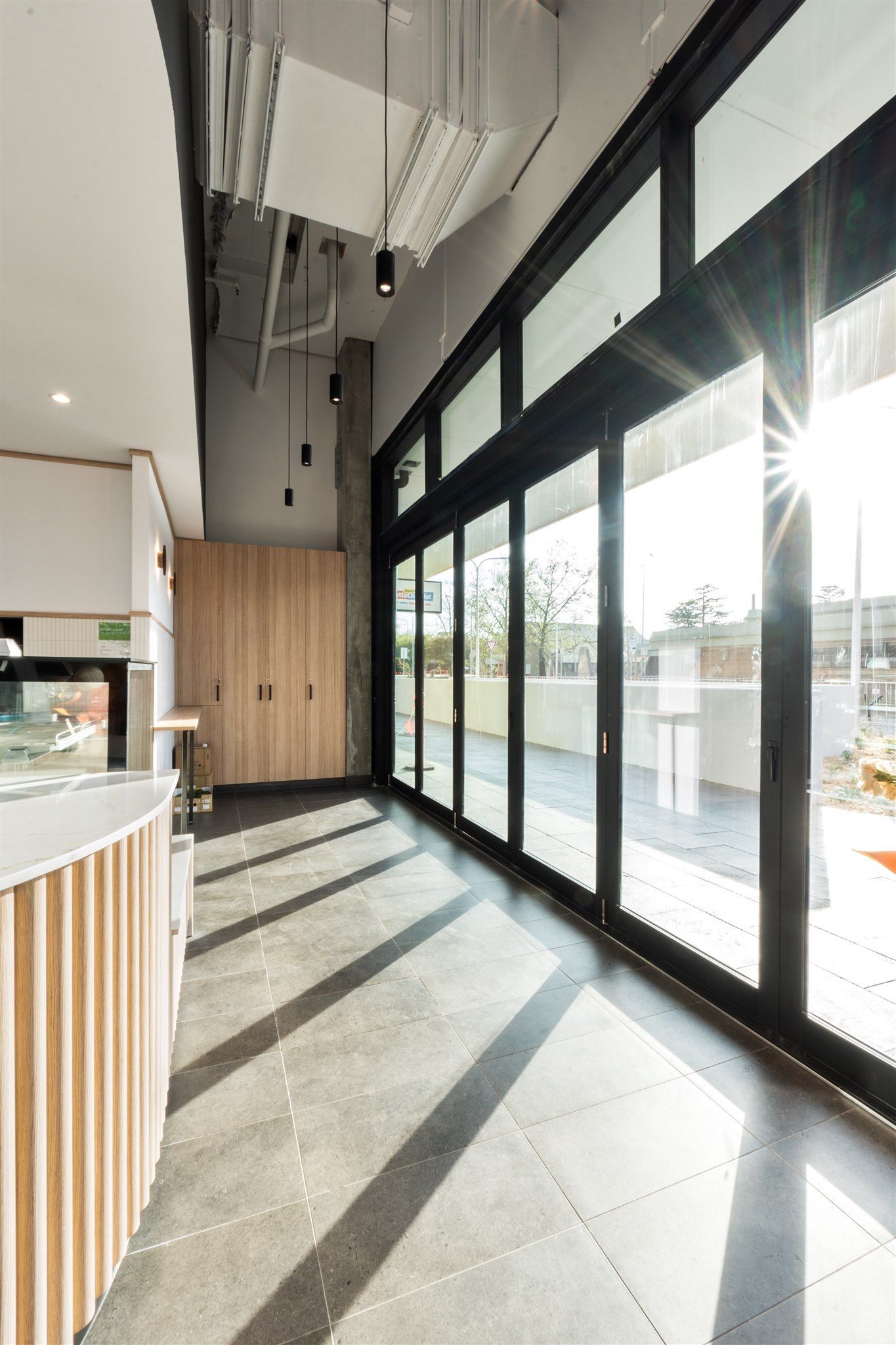 A Long Hallway With a Lot of Windows and the Sun Shining Through Them — Moltus Construction in Braddon,  ACT