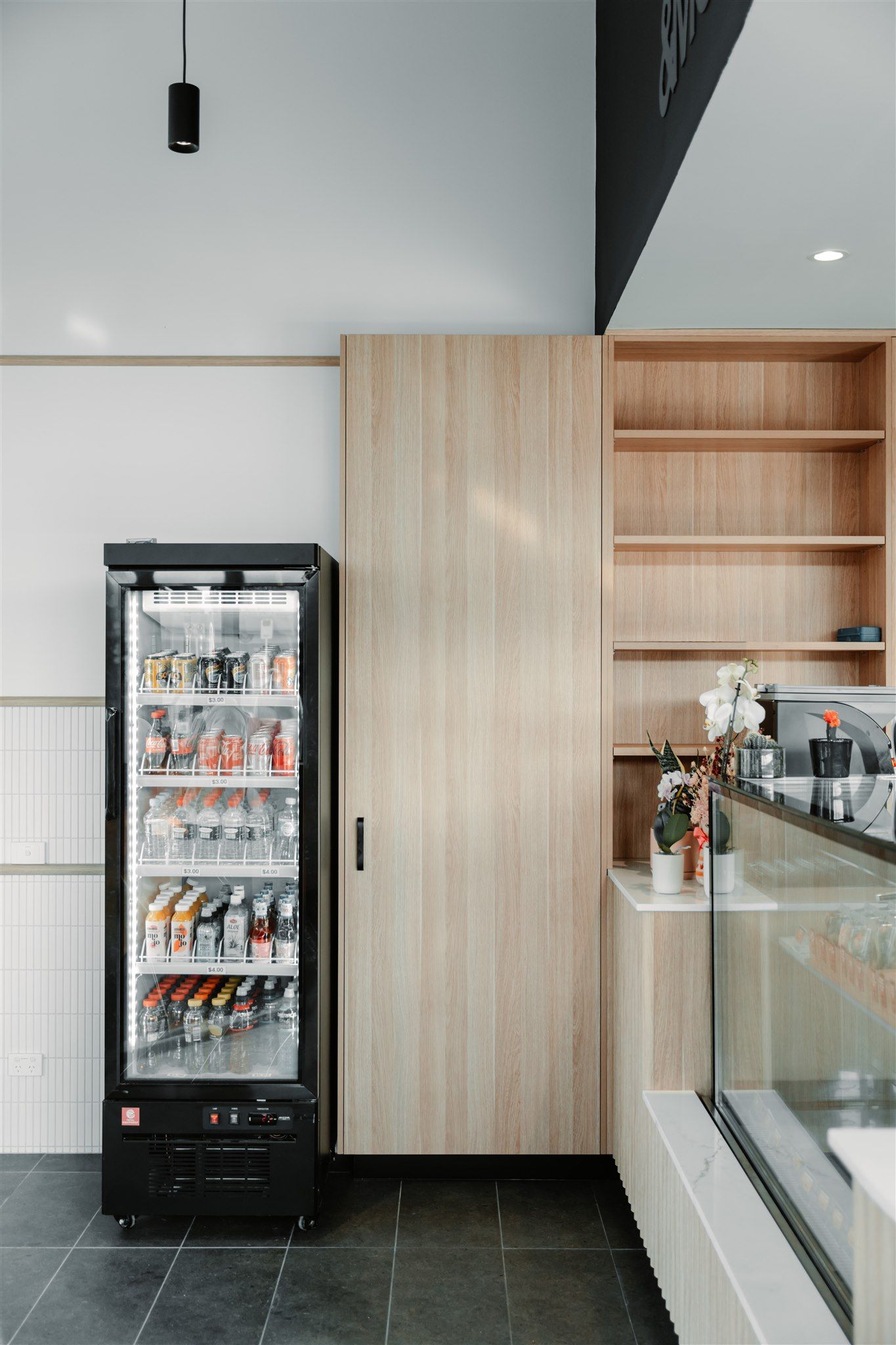 A Refrigerator Filled With Drinks is in a Kitchen Next to a Counter — Moltus Construction in Braddon,  ACT