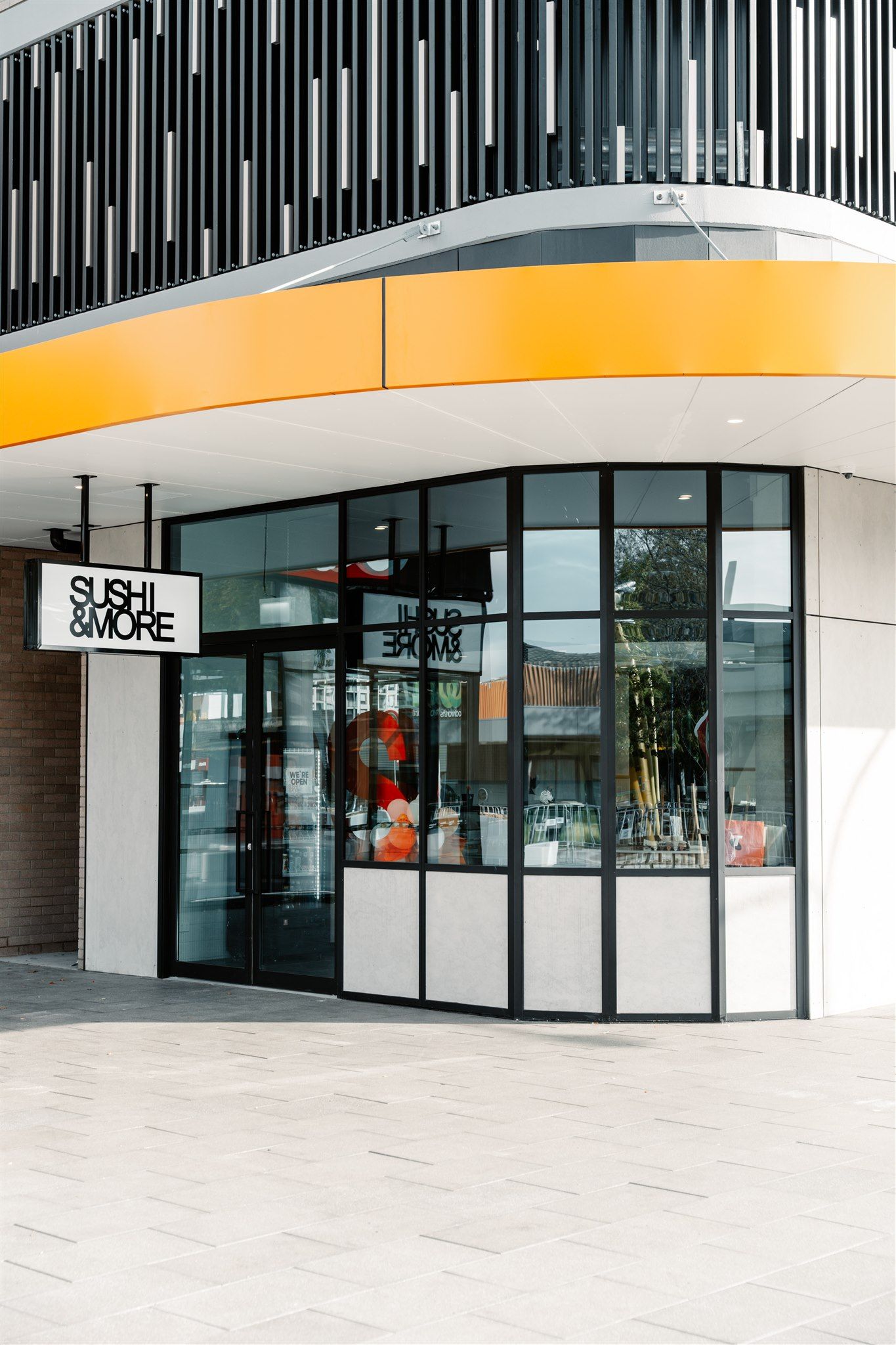 The Front of a Building With a Yellow Awning and a Sign on It — Moltus Construction in Braddon,  ACT