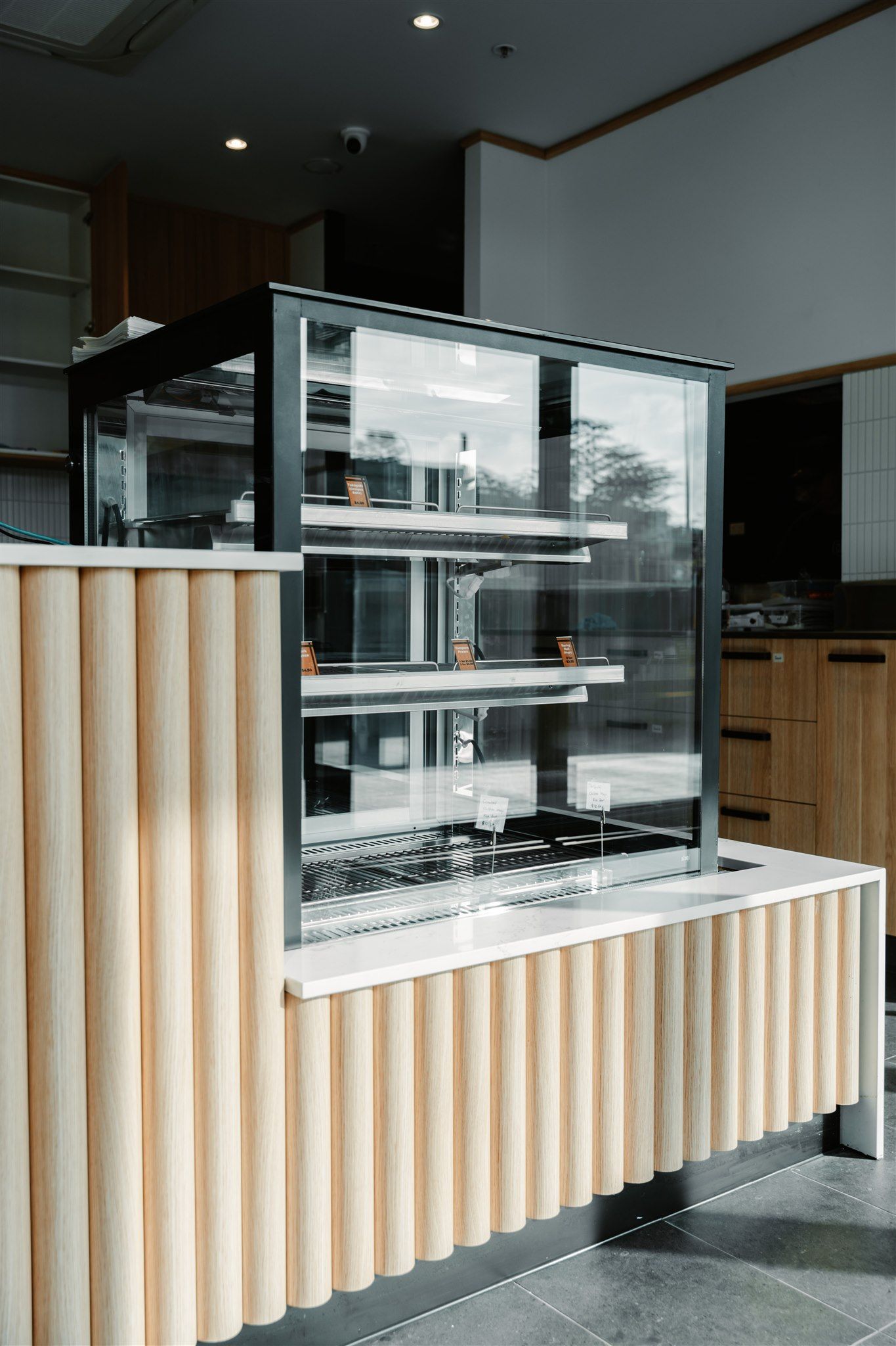 A Bakery With a Glass Display Case and a Wooden Counter — Moltus Construction in Braddon,  ACT