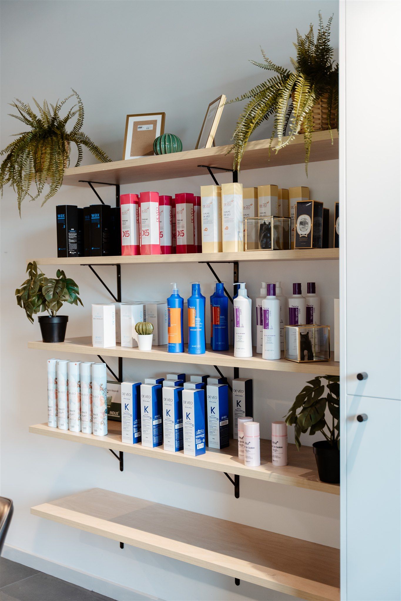 A Shelf Filled With Lots of Hair Products in a Salon — Moltus Construction in Braddon,  ACT