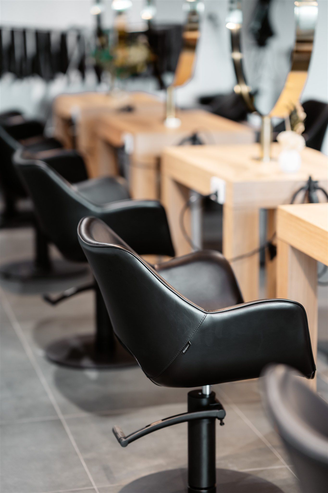 A Row of Black Chairs in a Hair Salon — Moltus Construction in Braddon,  ACT