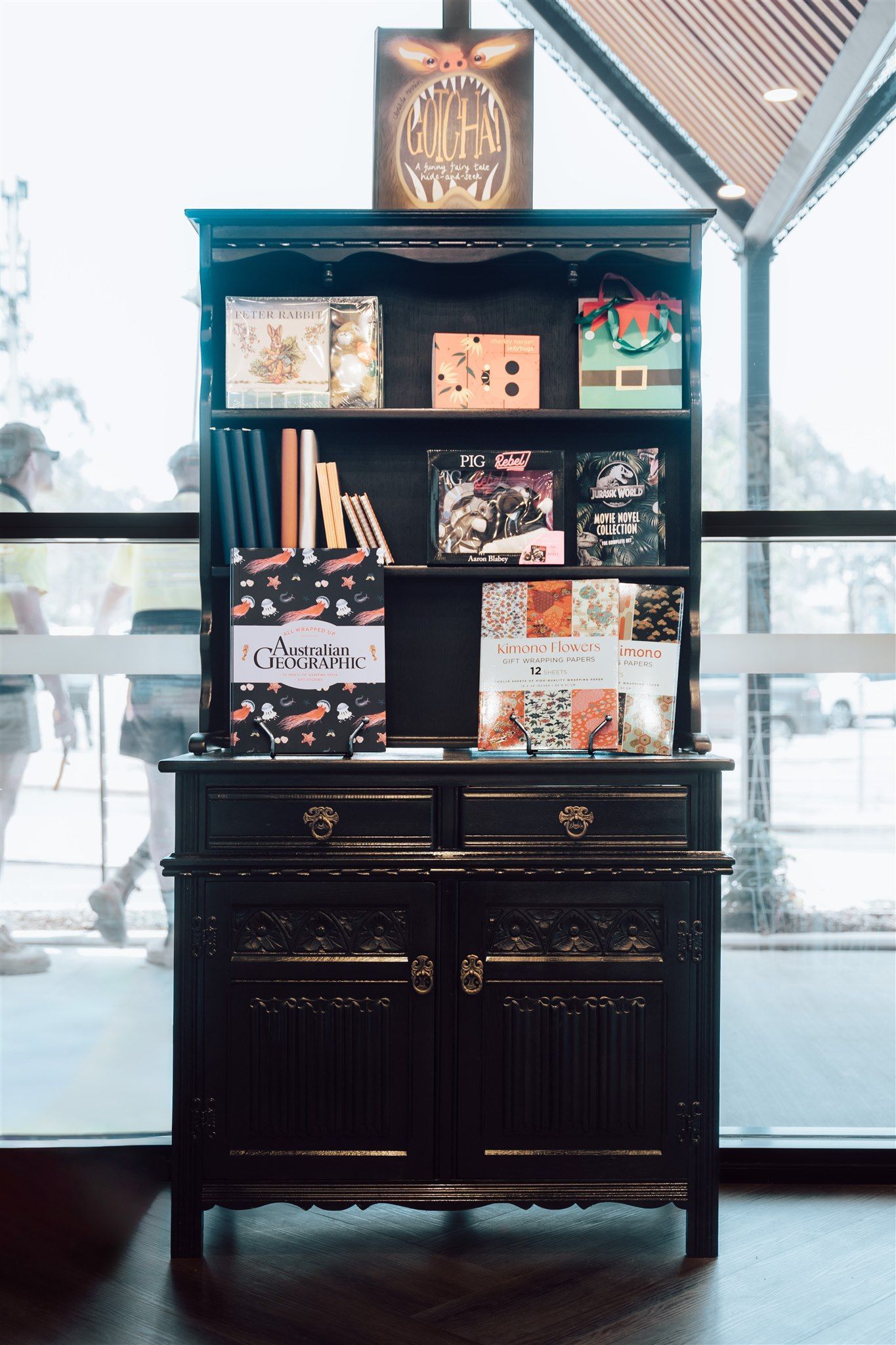 A Black Bookshelf With Books on It is Sitting in Front of a Window — Moltus Construction in Braddon, ACT