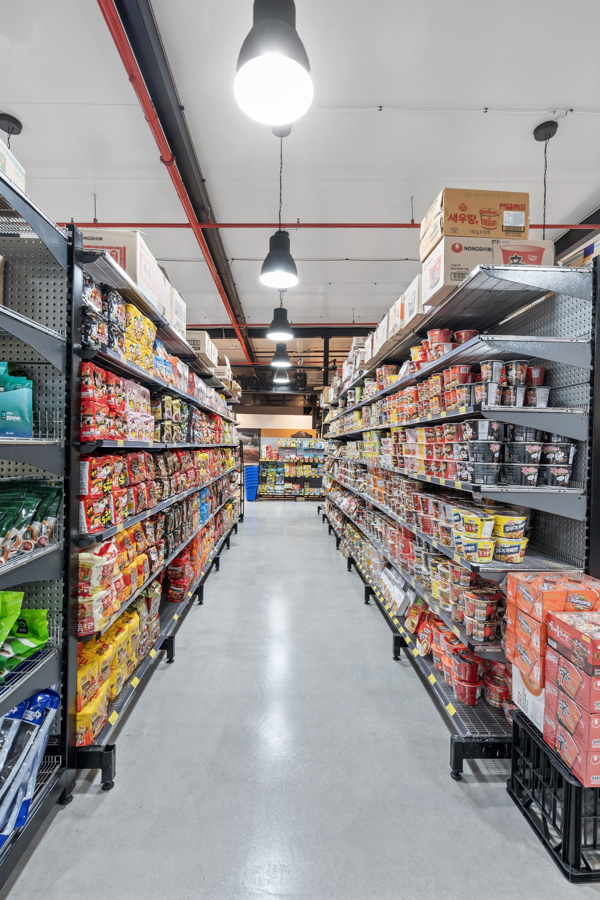 A Long Aisle of a Grocery Store Filled With Lots of Products — Moltus Construction in Braddon,  ACT