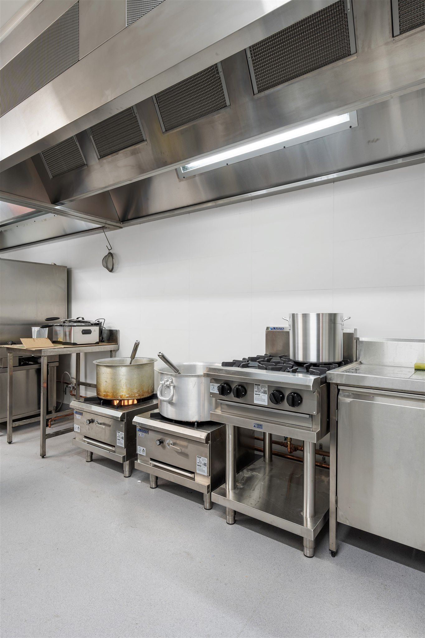 A Kitchen With a Lot of Pots and Pans on the Stove — Moltus Construction in Braddon,  ACT