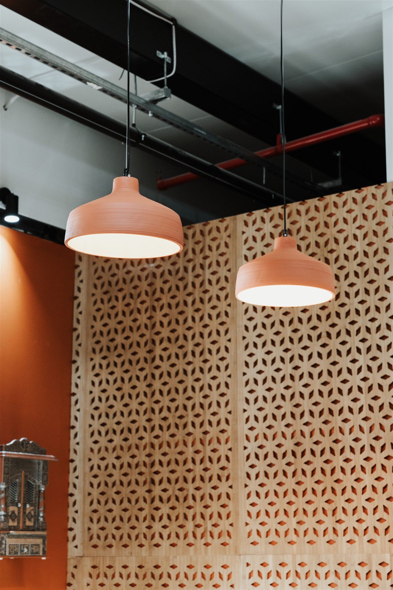Two Pink Pendant Lights Are Hanging From the Ceiling in a Room — Moltus Construction in Braddon,  ACT