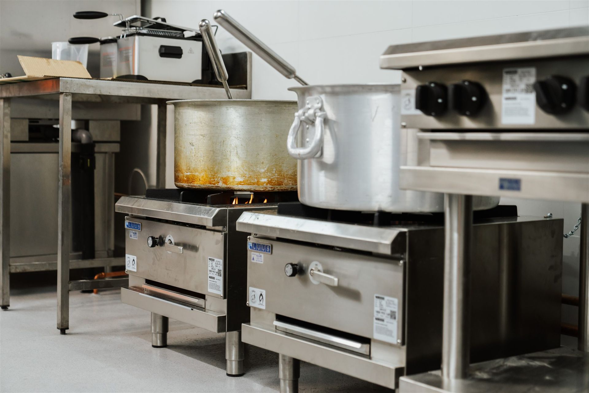 Two Pots Are Cooking on a Stove in a Kitchen — Moltus Construction in Braddon,  ACT