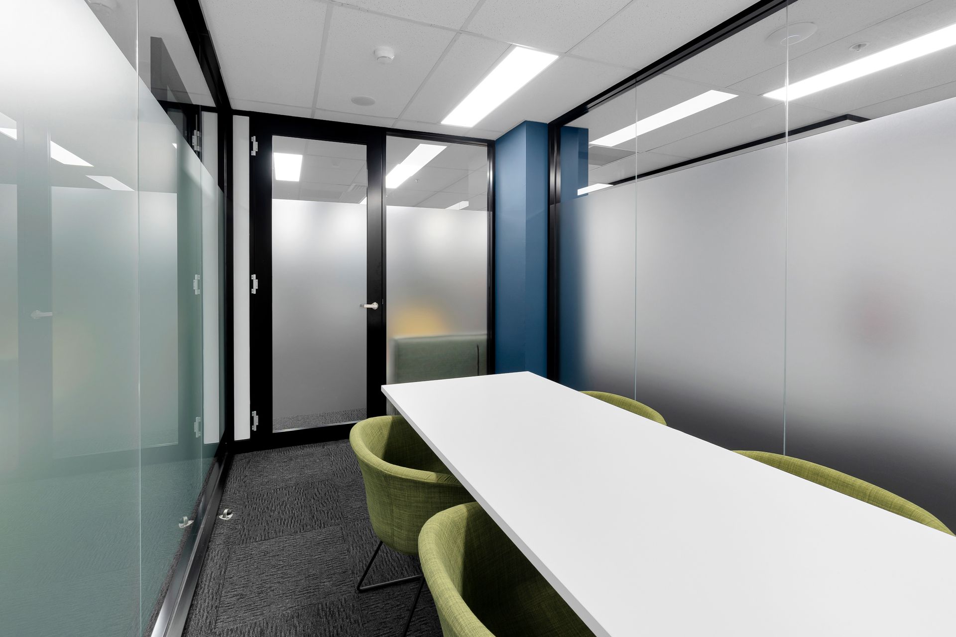A Conference Room With a Long Table and Green Chairs — Moltus Construction in Braddon,  ACT