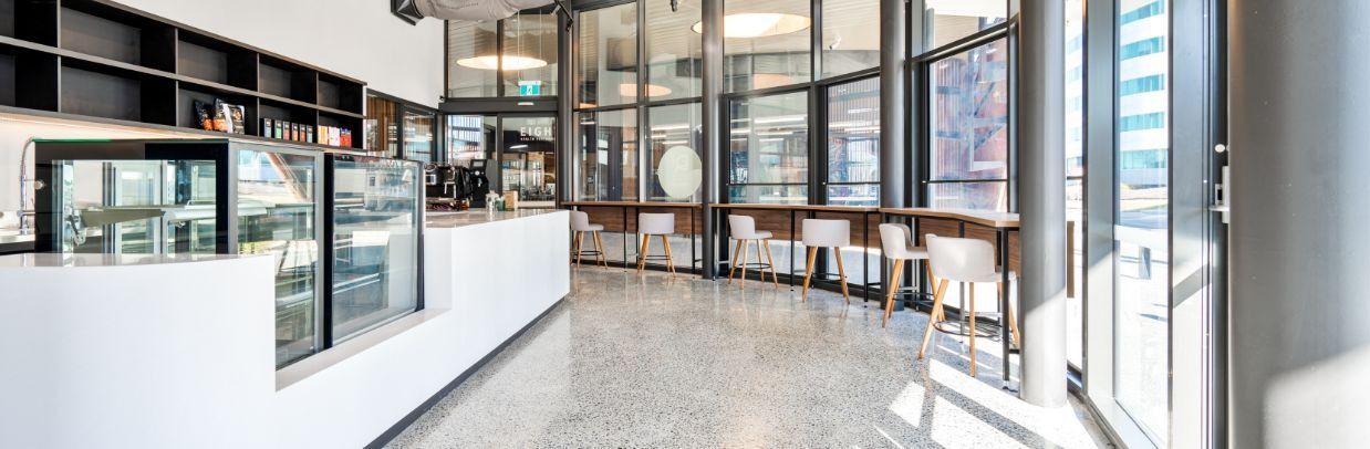 A Large Building With A Lot Of Windows And A Sign That Says Sushi & More  — Moltus Construction in Braddon, ACT