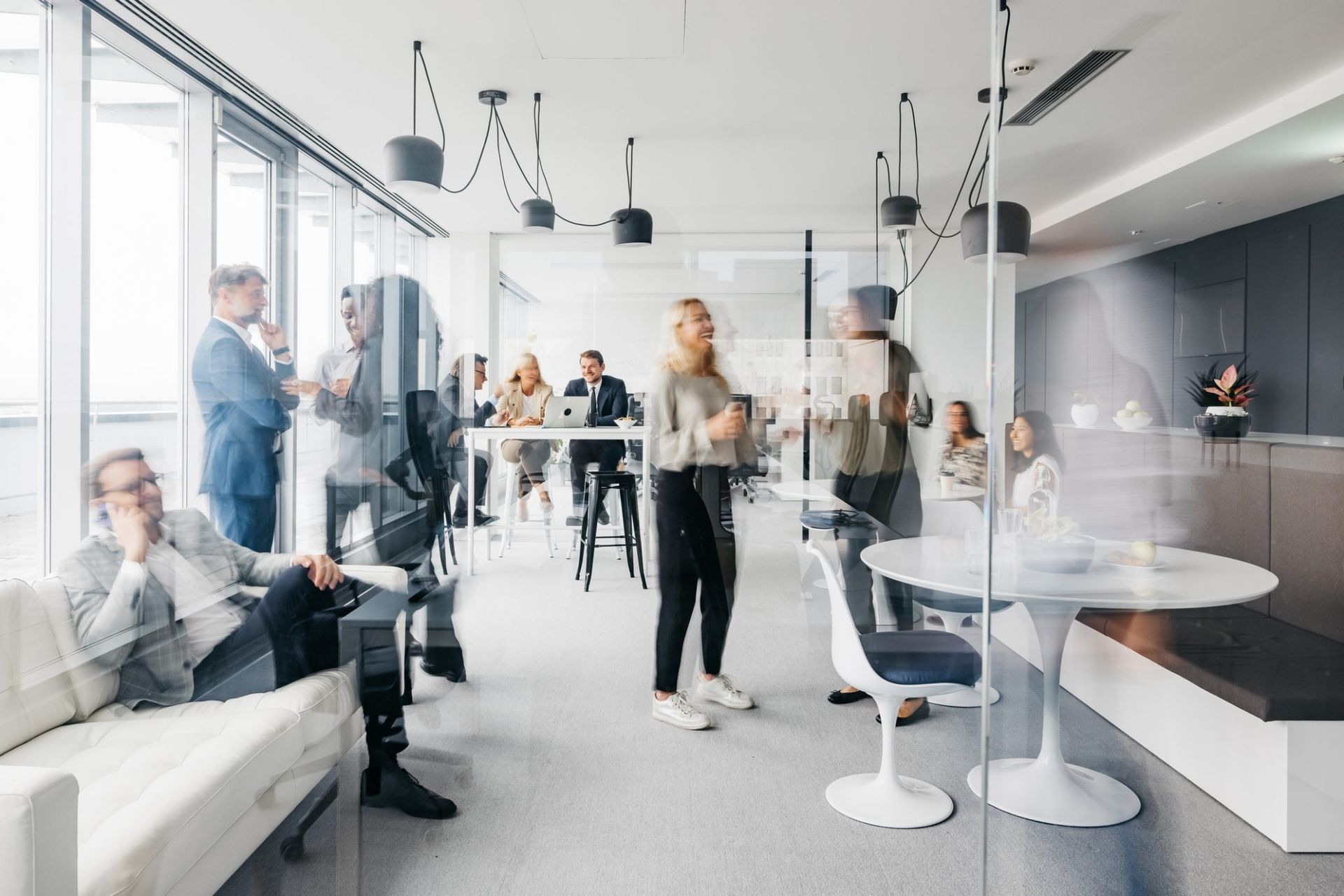 A Group of People Are Standing Around a Table in an Office — Moltus Construction in Braddon,  ACT