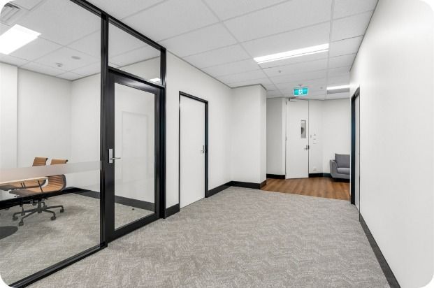A Hallway With a Glass Wall and a Conference Room in the Background — Moltus Construction in Braddon,  ACT