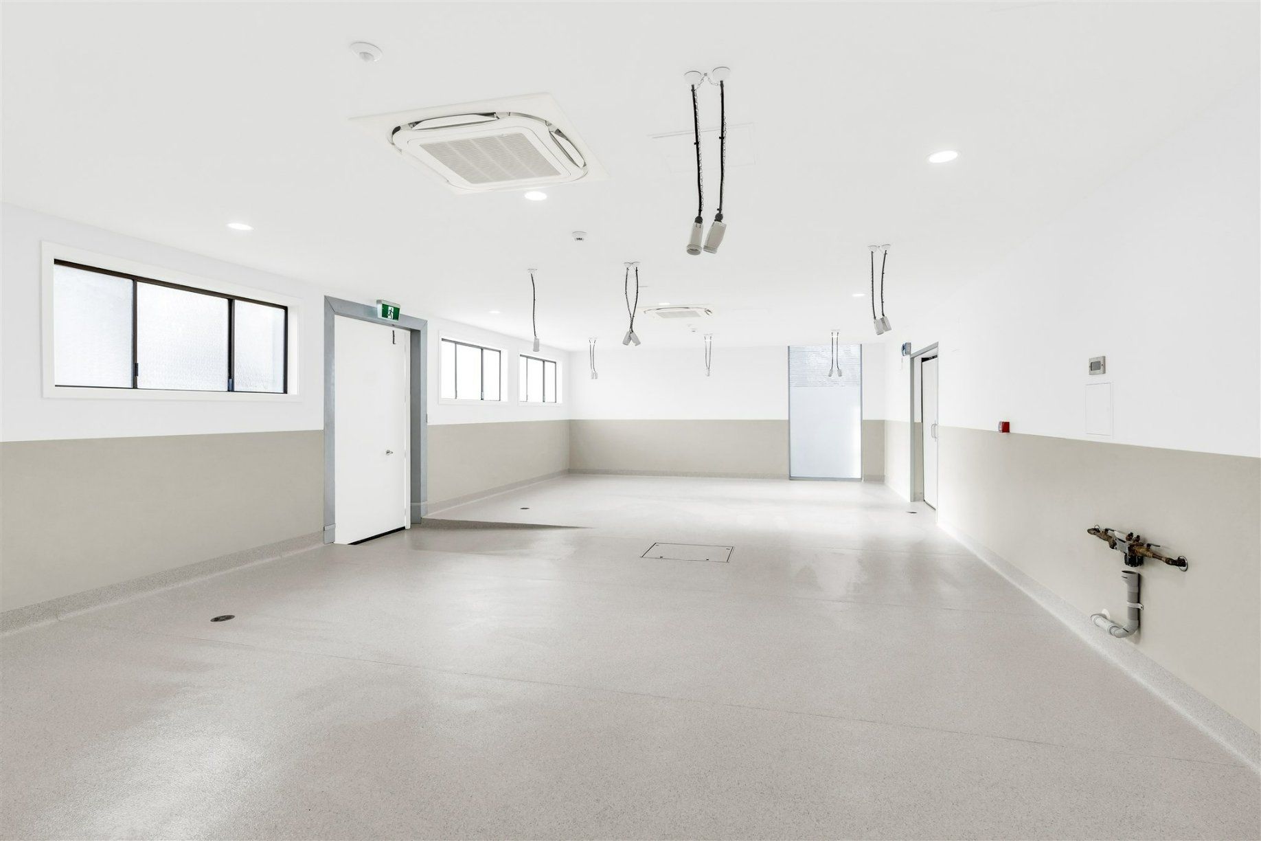 A Large Empty Room With White Walls and a White Floor — Moltus Construction in Braddon,  ACT