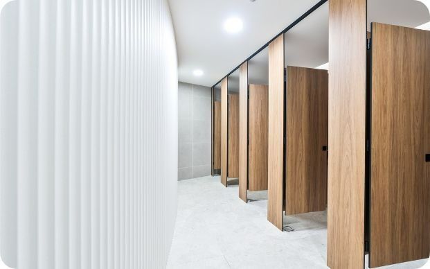 A Row of Wooden Toilet Cubicles in a Public Restroom — Moltus Construction in Braddon,  ACT