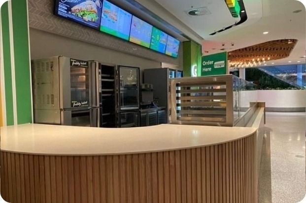 A Restaurant With a Counter and a Large Screen Above It — Moltus Construction in Braddon,  ACT