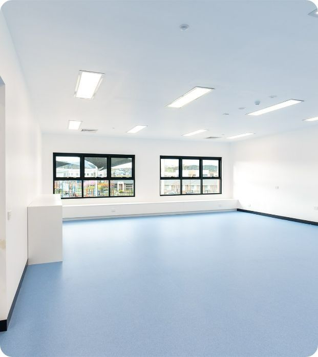 An Empty Room With Blue Floors and White Walls — Moltus Construction in Braddon,  ACT